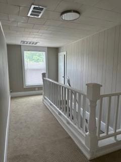 hallway with wood walls and carpet floors