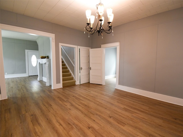 unfurnished dining area featuring wood-type flooring and an inviting chandelier