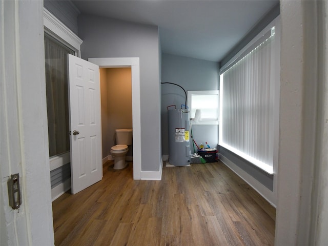 bathroom featuring water heater, toilet, and hardwood / wood-style flooring