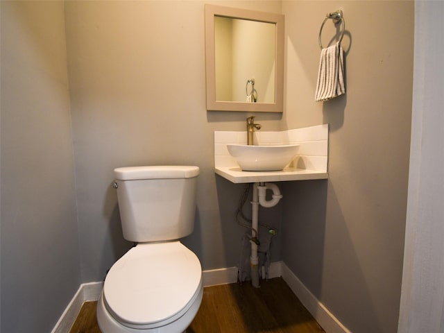 bathroom with hardwood / wood-style flooring, toilet, and sink