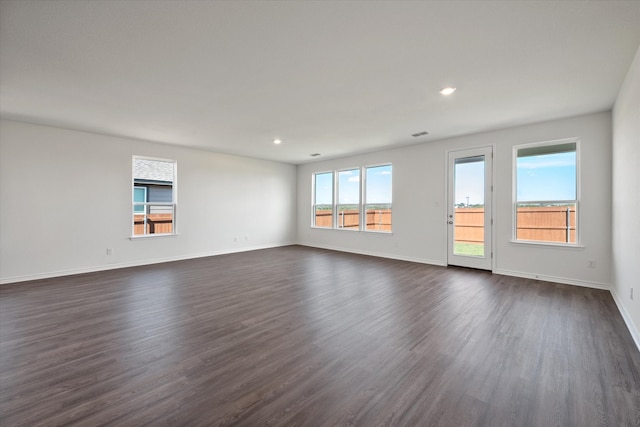 unfurnished room with a wealth of natural light and dark hardwood / wood-style floors