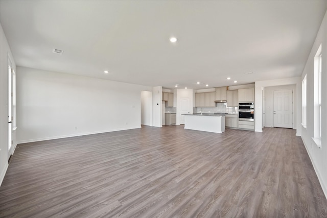 unfurnished living room with hardwood / wood-style floors and sink