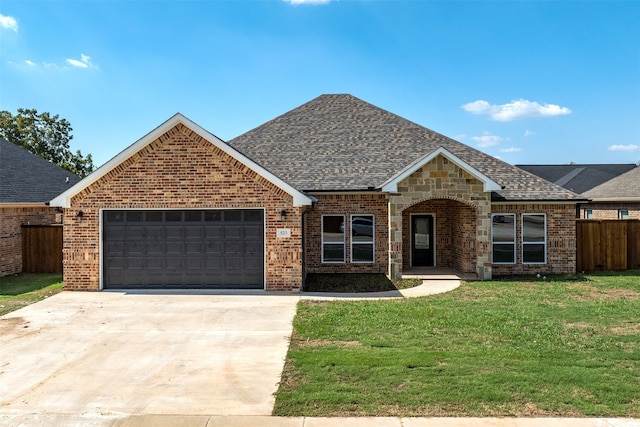 view of front of property featuring a front yard and a garage