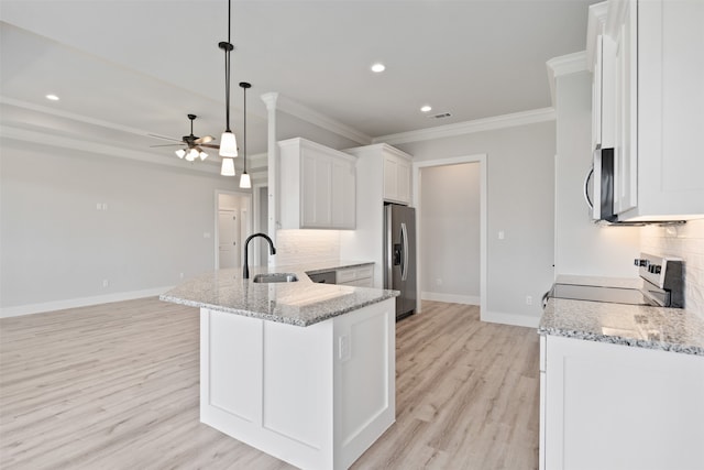 kitchen with white cabinets, sink, light hardwood / wood-style flooring, decorative light fixtures, and stainless steel appliances