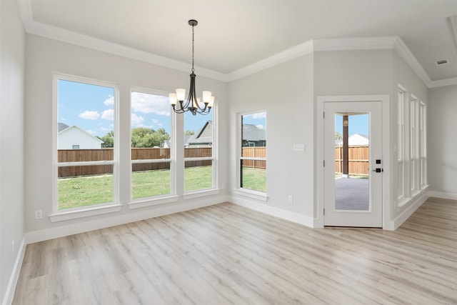 unfurnished dining area with plenty of natural light, ornamental molding, and light wood-type flooring