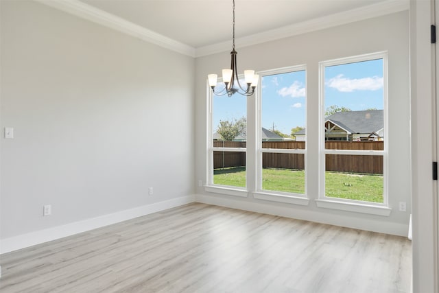 unfurnished dining area featuring a notable chandelier, crown molding, light hardwood / wood-style floors, and a wealth of natural light