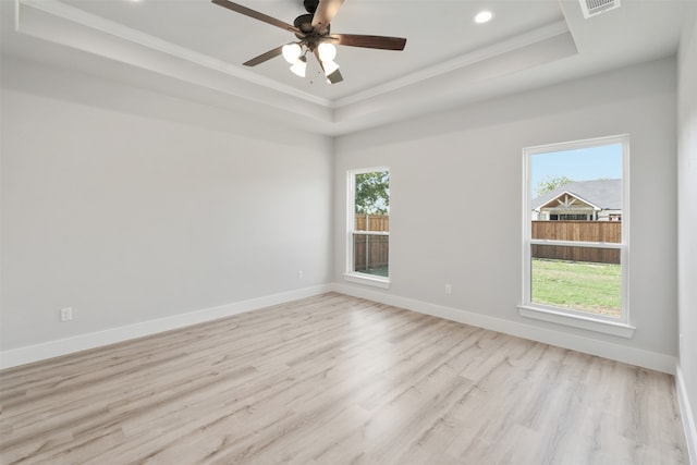 unfurnished room featuring ornamental molding, a tray ceiling, light wood-type flooring, and ceiling fan