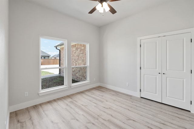 unfurnished bedroom with ceiling fan, light hardwood / wood-style flooring, and a closet