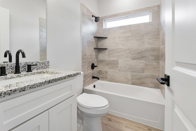 full bathroom with toilet, vanity, wood-type flooring, and tiled shower / bath combo