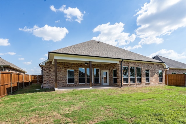 rear view of property featuring a yard and a patio area