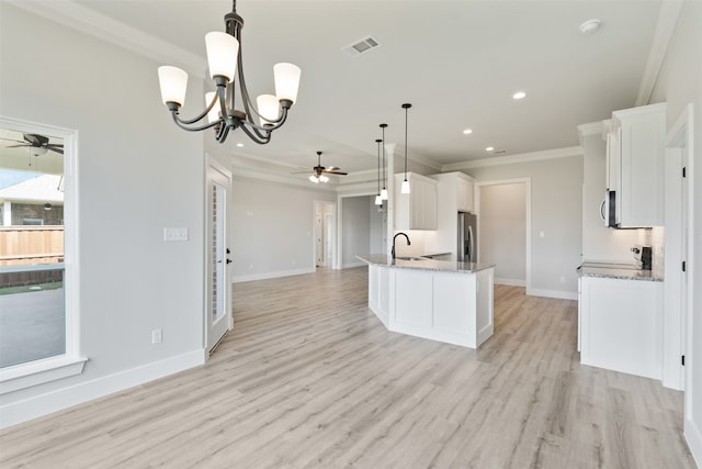 kitchen with hanging light fixtures, stainless steel refrigerator with ice dispenser, light wood-type flooring, and white cabinetry