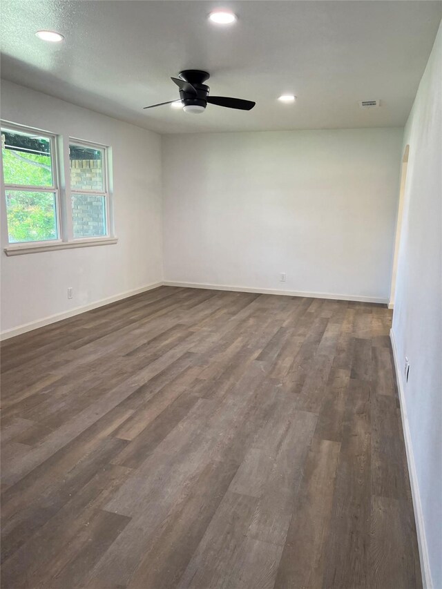 spare room with ceiling fan and dark hardwood / wood-style flooring