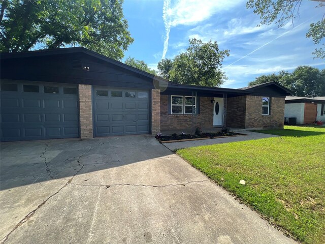 ranch-style house featuring a garage and a front lawn