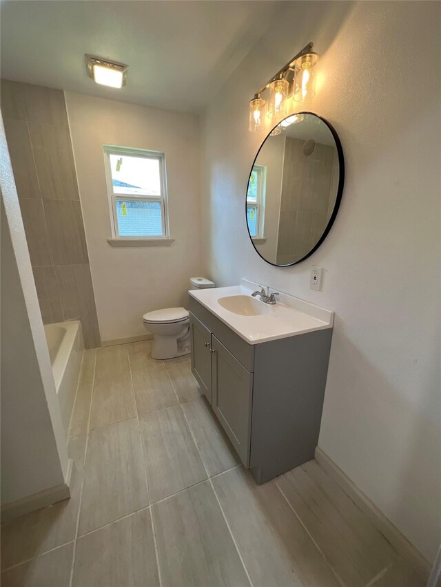 bathroom with tile patterned flooring, a bathing tub, toilet, and vanity