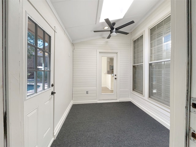 unfurnished sunroom featuring lofted ceiling with skylight and ceiling fan