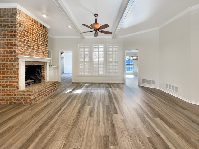 unfurnished living room with hardwood / wood-style flooring, beamed ceiling, crown molding, a brick fireplace, and ceiling fan