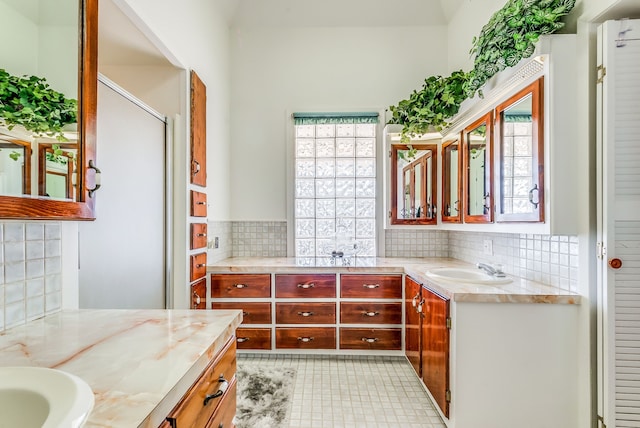 bathroom with an enclosed shower, vanity, and backsplash