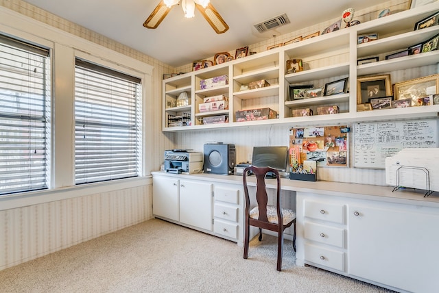 office with built in desk and light carpet