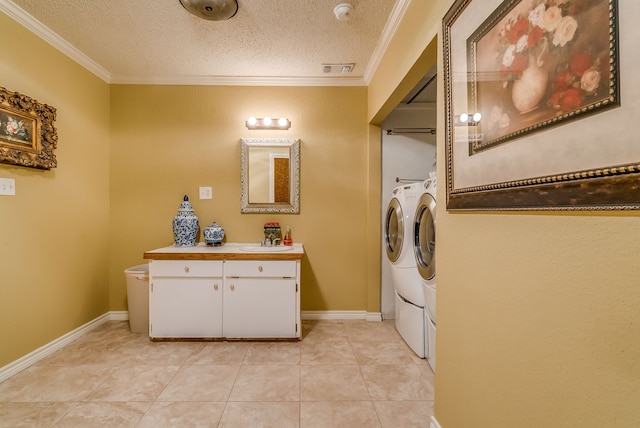 clothes washing area featuring a textured ceiling, washer and clothes dryer, crown molding, and sink