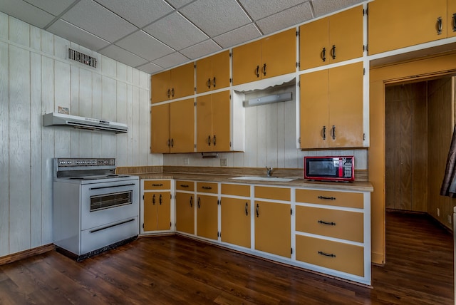 kitchen with a paneled ceiling, white electric range oven, wooden walls, dark hardwood / wood-style floors, and sink