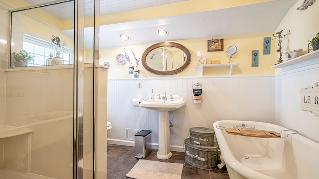 bathroom featuring toilet and separate shower and tub