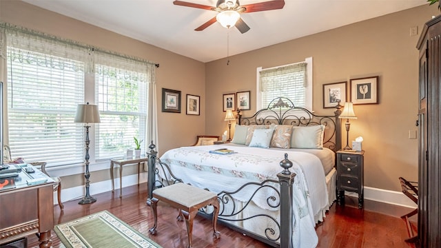 bedroom with multiple windows, ceiling fan, and dark wood-type flooring