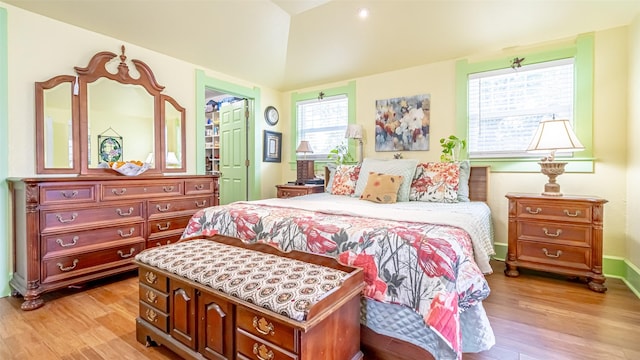 bedroom with light hardwood / wood-style floors and multiple windows