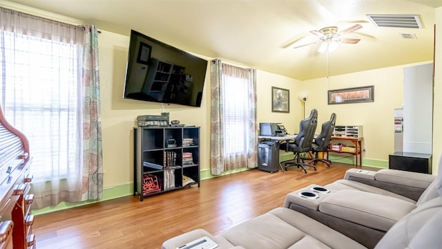 living room featuring wood-type flooring and ceiling fan