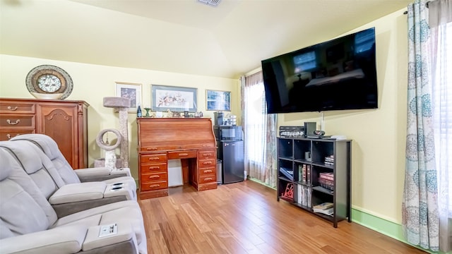 living room featuring vaulted ceiling and light hardwood / wood-style flooring