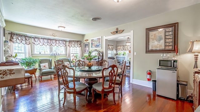 dining space with dark hardwood / wood-style flooring and a wealth of natural light