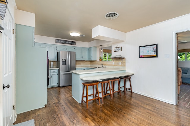 kitchen featuring stainless steel refrigerator with ice dispenser, dark hardwood / wood-style flooring, tasteful backsplash, and kitchen peninsula