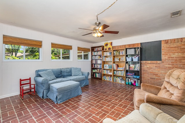 living room with brick wall and ceiling fan