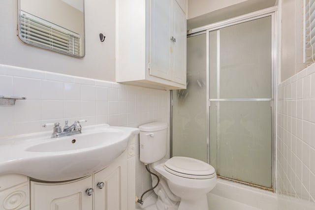 bathroom featuring tile walls, a shower with door, tasteful backsplash, large vanity, and toilet