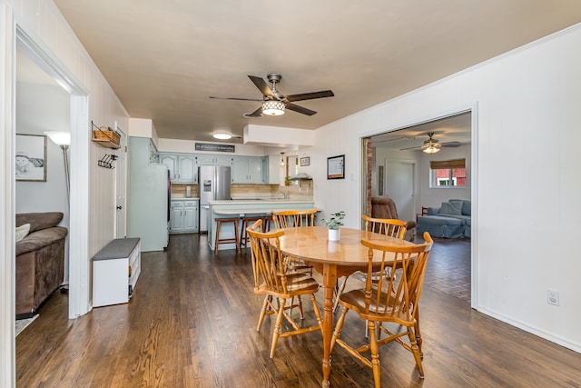 dining area with dark wood-type flooring and ceiling fan