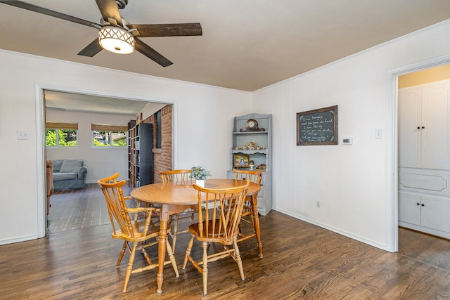 dining area with ceiling fan, dark hardwood / wood-style flooring, ornamental molding, and brick wall