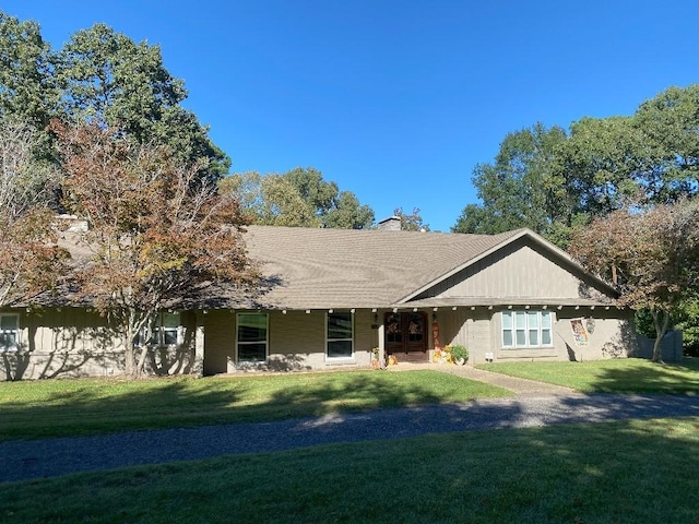 rear view of house featuring a lawn and a chimney