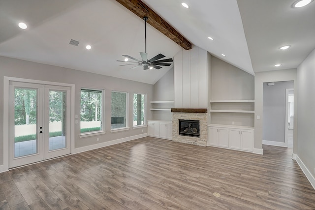 unfurnished living room with a stone fireplace, plenty of natural light, ceiling fan, and hardwood / wood-style floors