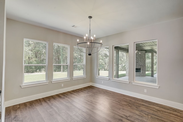 unfurnished dining area featuring a notable chandelier and dark hardwood / wood-style flooring