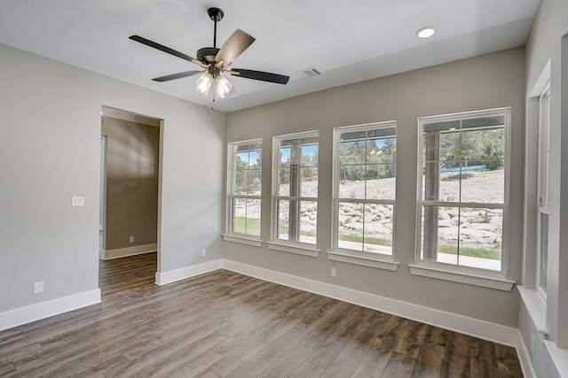 unfurnished room with a wealth of natural light, ceiling fan, and dark hardwood / wood-style floors