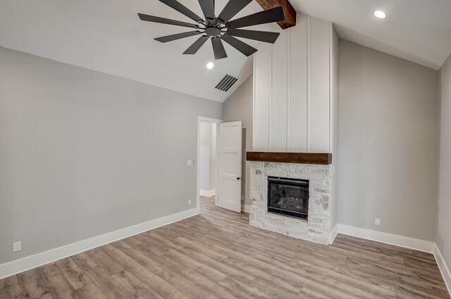 unfurnished living room with a fireplace, light hardwood / wood-style flooring, beamed ceiling, high vaulted ceiling, and ceiling fan