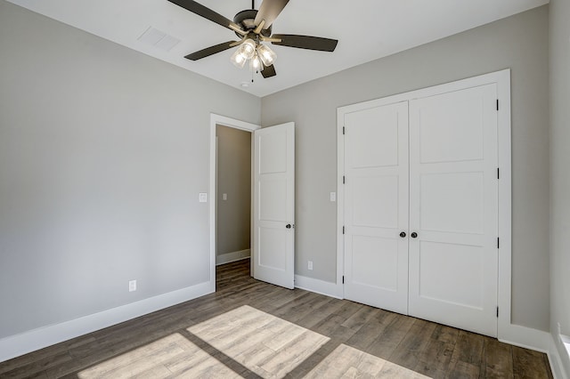 unfurnished bedroom featuring ceiling fan, a closet, and hardwood / wood-style flooring