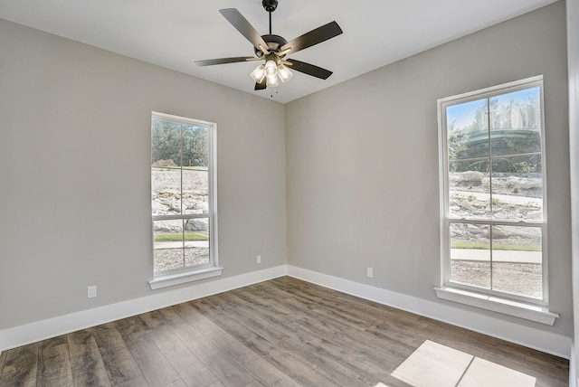 spare room featuring ceiling fan, a wealth of natural light, and wood-type flooring