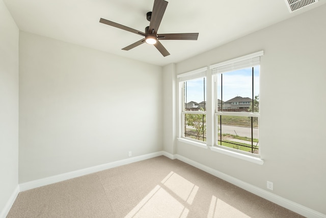 carpeted spare room with ceiling fan