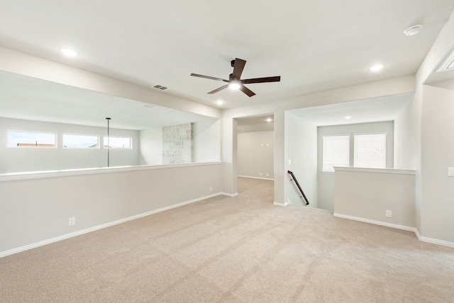 carpeted spare room with a healthy amount of sunlight and ceiling fan