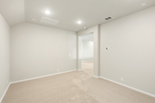 unfurnished room with lofted ceiling and light colored carpet