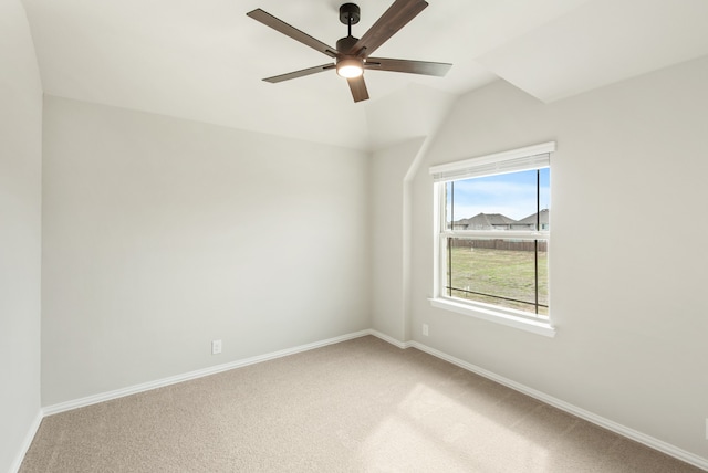 empty room featuring lofted ceiling, carpet, and ceiling fan