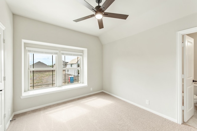 empty room with light colored carpet, lofted ceiling, and ceiling fan