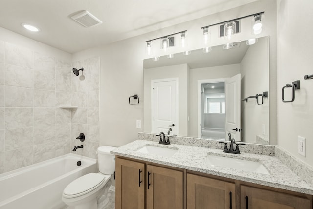 full bathroom featuring tiled shower / bath combo, vanity, and toilet