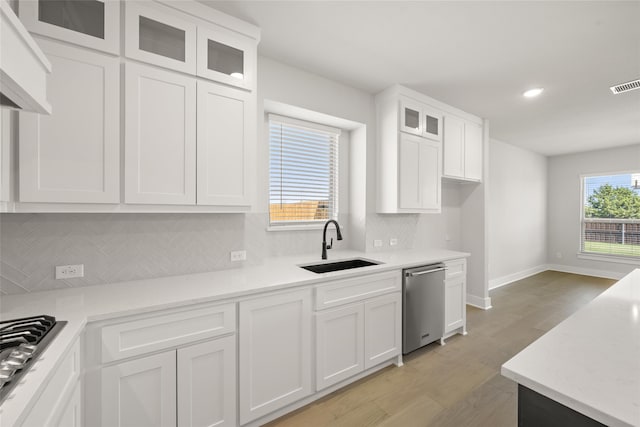 kitchen featuring dishwasher, white cabinetry, plenty of natural light, and light hardwood / wood-style floors