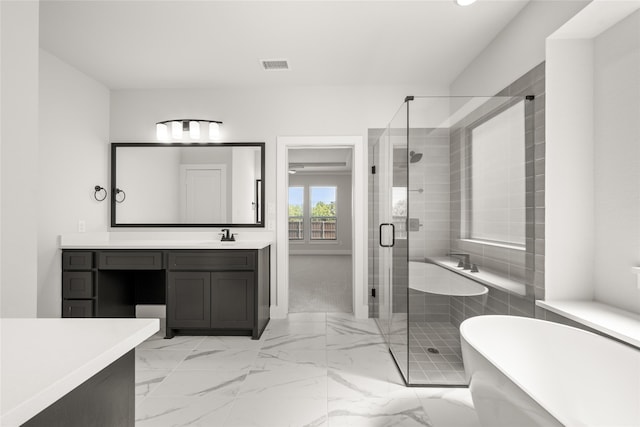 bathroom with vanity and shower with separate bathtub